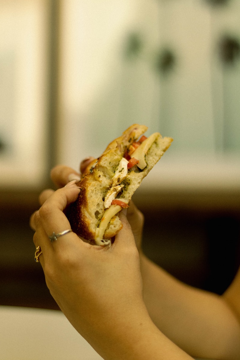 a person holding a sandwich in their hand